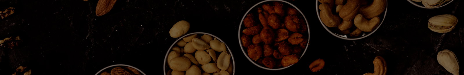 A slate with almonds, peanuts, cashews and pistachios