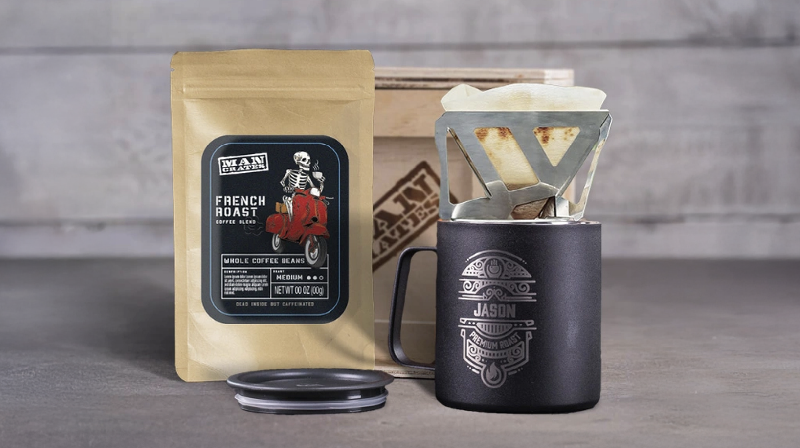 A laser engraved personalized coffee mug with a fold-out pourover kit. Next to it is a bag of Mancrates French Roast coffee beans. 