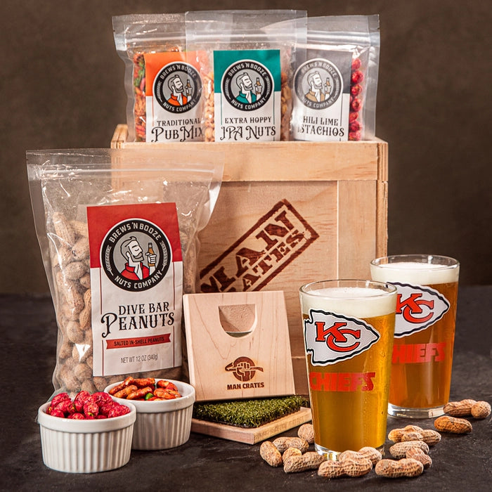 A Kansas City Chiefs football fan gift crate with personalized beer glasses and various peanut snacks
